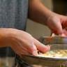 A close-up image of hands gently mixing ingredients in a bowl